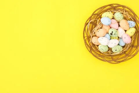 Happy Easter. Pastel colored eggs for Easter in decorated basket Stock Photos