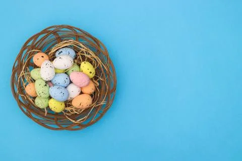 Happy Easter. Pastel colored eggs for Easter in decorated basket Stock Photos