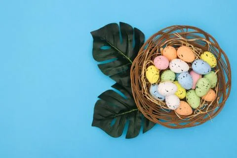 Happy Easter. Pastel colored eggs for Easter in decorated basket Stock Photos