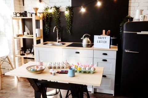 Happy Easter preparation, Easter eggs on the kitchen table, paints and brushers. Stock Photos