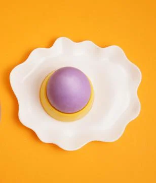 Happy Easter. Purple egg on an egg stand. Breakfast. Orange background. Foto stock