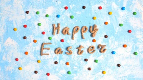 Happy Easter rope typography congratulation among moving dragee candies. Stock Footage 123904003