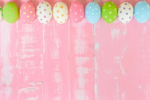 Happy easter! Row Easter eggs with colorful paper flowers on bright pink wood Stock Photos