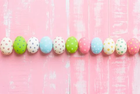 Happy easter! Row Easter eggs with colorful paper flowers on bright pink wood Stock Photos