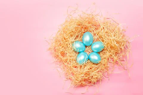 Happy easter simple background, colored pearl blue eggs in hay nest over brig Stock Photos