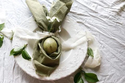 Happy Easter! Stylish dyed egg in bunny ears napkin and spring flowers  on .. 스톡 사진