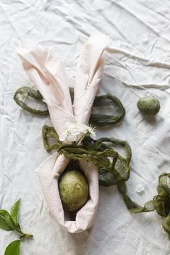 Happy Easter! Stylish dyed egg in bunny ears napkin and spring flowers on t.. 스톡 사진