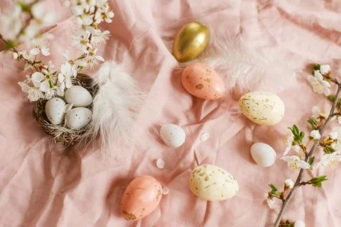 Happy Easter! Stylish easter eggs and blooming spring flowers on pink linen.. Stock Photos