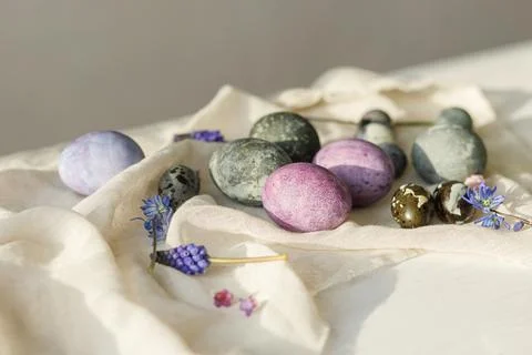 Happy Easter! Stylish easter eggs and spring flowers on linen cloth on rust.. Stock Photos