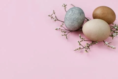Happy Easter! Stylish eggs and flowers on pink background. Modern border, e.. Stock Photos