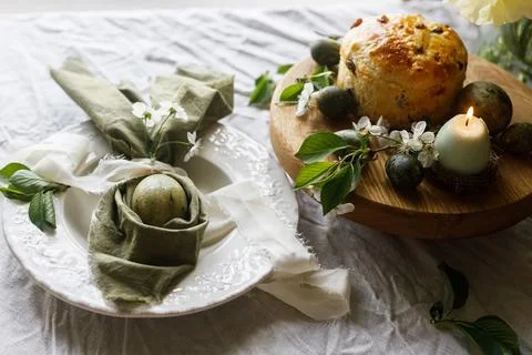Happy Easter! Stylish eggs in bunny ears napkin on plate, easter cake on st.. Stock Photos