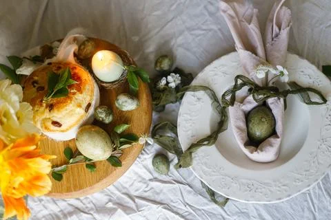 Happy Easter! Stylish eggs in bunny ears napkin on plate, easter cake on st.. 스톡 사진