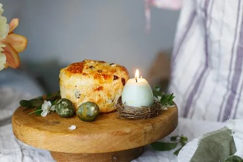 Happy Easter! Stylish eggs, easter cake on stand, spring flowers and candle. Stock Photos