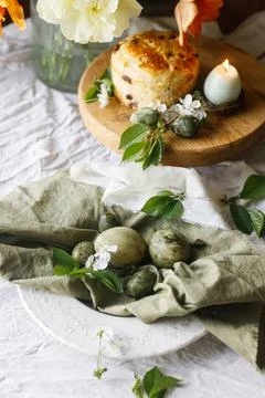 Happy Easter! Stylish eggs on napkin on plate, easter cake on stand, spring.. 库存照片