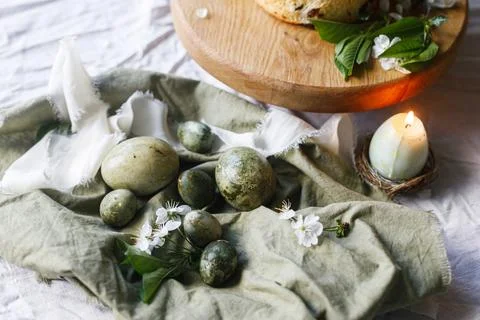Happy Easter! Stylish eggs on napkin on plate, easter cake on stand, spring.. Stock Photos