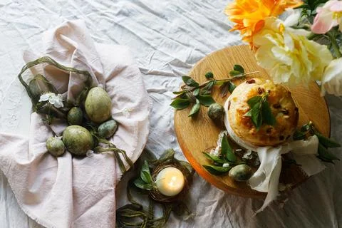 Happy Easter! Stylish eggs on napkin on plate, easter cake on stand, spring.. Stock Photos