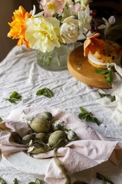 Happy Easter! Stylish eggs on napkin on plate, easter cake on stand, spring.. Stockfoto's