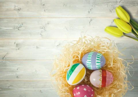 Happy Easter table with flowers and nest with eggs. Stock Fotos