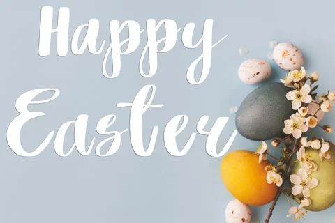 Happy Easter text and modern stylish  blue and yellow easter eggs, cherry b.. Stock Photos