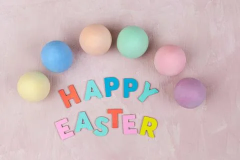 Happy Easter text with colorful eggs - top view Stock Photos