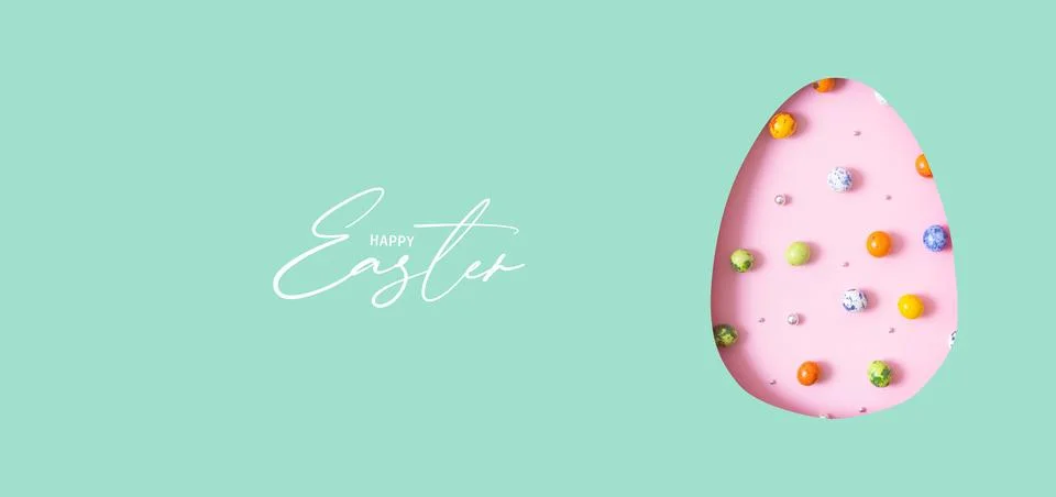 Happy Easter text with Easter egg cut out of paper and chocolate mini eggs... Stock Photos