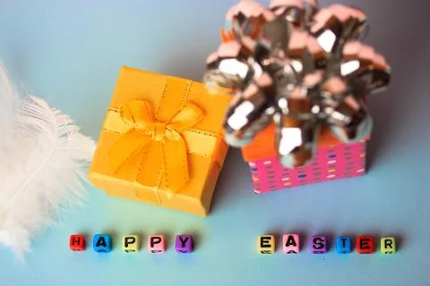 Happy Easter text of multicolored beads and gift boxes on a blue background. Stock-Fotos