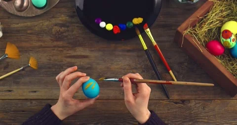 Happy easter. Top view video of female artist's hands painting on eggs for Stock Footage 150957347