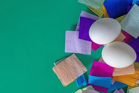 Happy Easter. Two white eggs with colored paper on a green background. Stock Photos