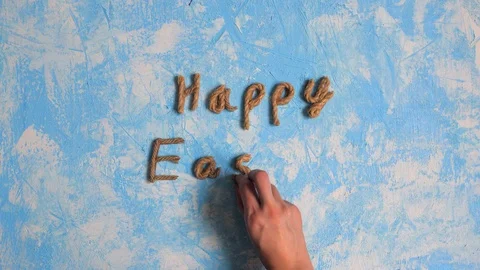 Happy Easter typography made of rope and chocolate eggs on the blue background. Video stock 123904191