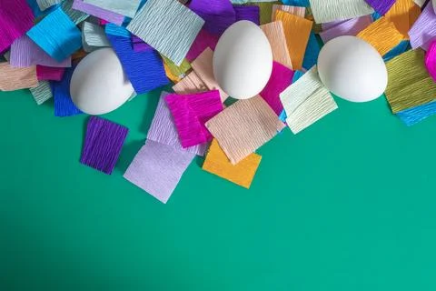 Happy Easter. White eggs with colored crepe paper on green background with .. Stock Photos