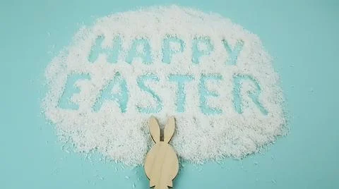 Happy Easter is written on a light blue background. easter bunny and ears are Stock Photos