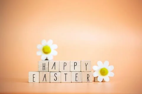 Happy Easter written with pastel colored orange background and bright spring Stock Photos