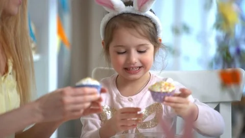 Happy Easter! Young mother and her little daughter cooking Easter cupcakes Stock Footage 84831976