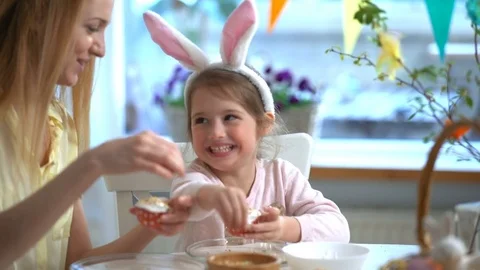 Happy Easter! Young mother and her little daughter cooking Easter cupcakes Stock Footage 84832461