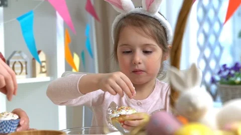 Happy Easter! Young mother and her little daughter cooking Easter cupcakes Stock Footage 84834911