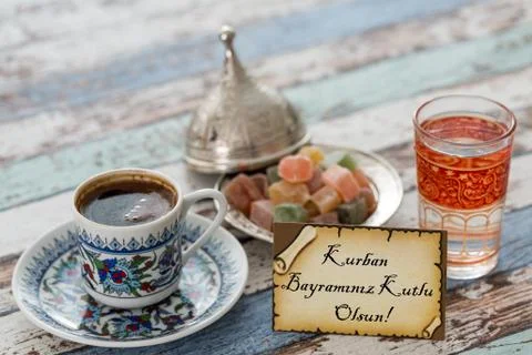 Happy eid al adna text in turkish on greeting card with turkish coffee, delights Stock Photos
