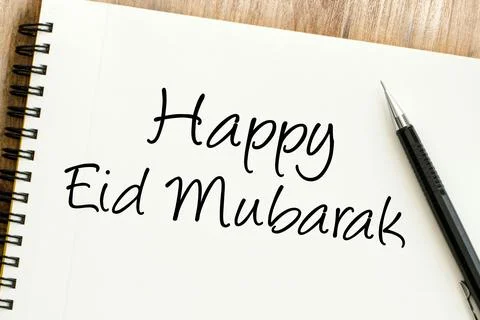 Happy Eid Mubarak message on a notebook, perfect for expressing joyful holi.. Stock Photos
