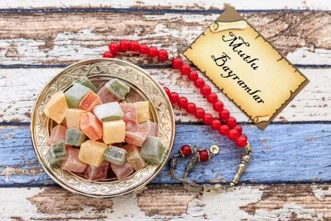 Happy Eid text in turkish on the card with turkish delights and rosary on vin Stock Photos