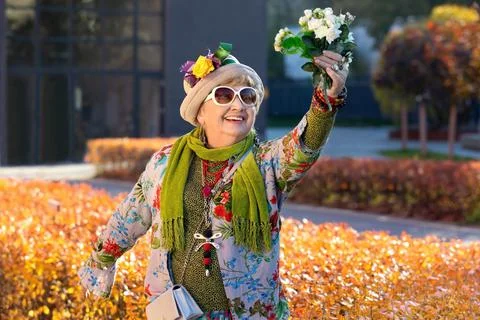 Happy eighty year old granny with a bouquet of flowers Stockfoto's
