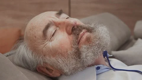 Happy elderly bearded man resting on sofa, relaxed enjoy stress free peaceful na Stock Footage 148945617
