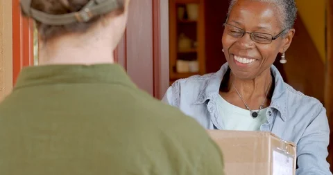 Happy elderly black woman receiving home delivery package delivery Stock Footage