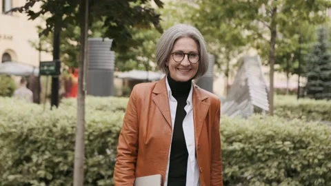 Happy elderly business gray-haired woman 60s years old in glasses walking down Stock Footage 233175806