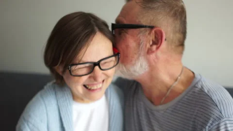 Happy elderly couple in love. Old man whispering secret to his wife. Gray-haired Video stock 139936983