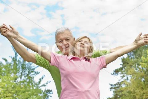 Happy elderly couple with raised arms Stock Photos