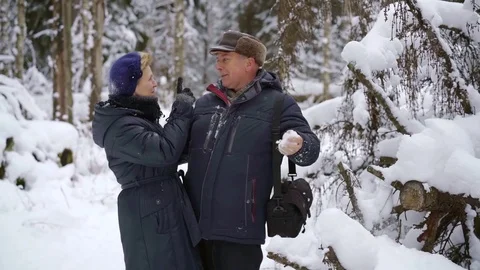 Happy elderly couple walking through the winter forest. Man playing with snow Video stock 101627565