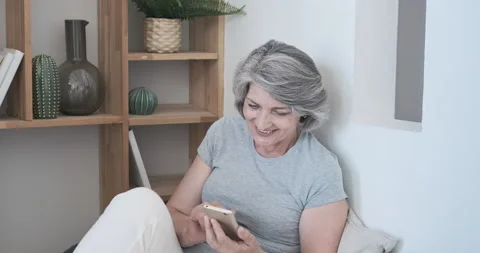 Happy elderly lady using smartphone, reading pleasant messages and chatting with Stock Footage 159167441