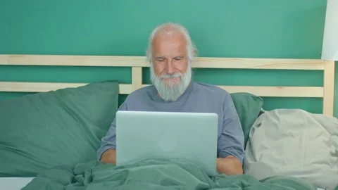 Happy Elderly Man Freelancer Works Remotely, Browses the Internet Using a Laptop Stock Footage 164413146