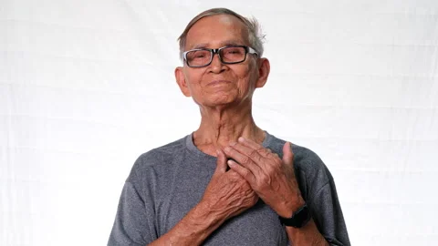 Happy elderly man holding hands on chest grateful heart on white background. Stock Footage 171316896