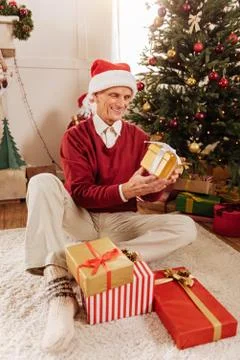 Happy elderly man opening presents Stock Photos