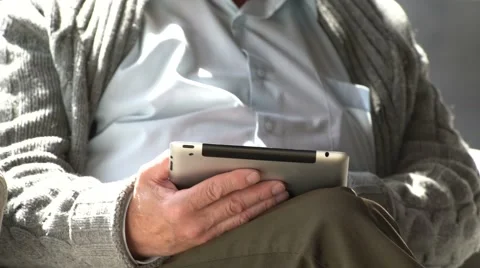 Happy elderly man is using tablet computer at home Stock Footage 63423603